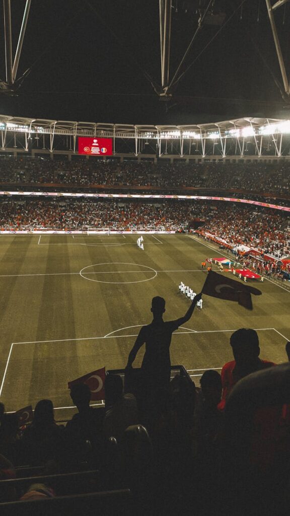 Exciting night soccer game with fans cheering in a vibrant stadium arena.